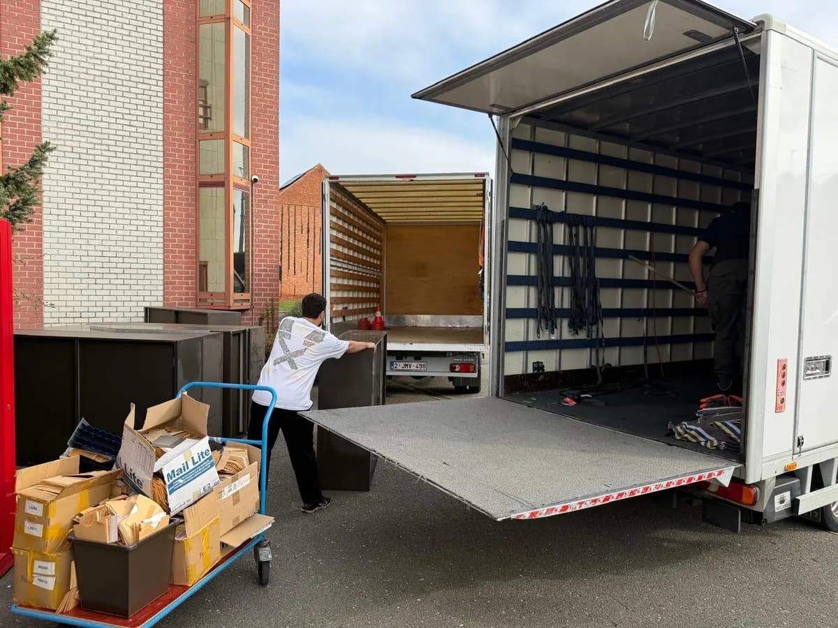 Inboedel opruimen: onze ploeg laadt kasten en dozen via de laadklep in de vrachtwagen
